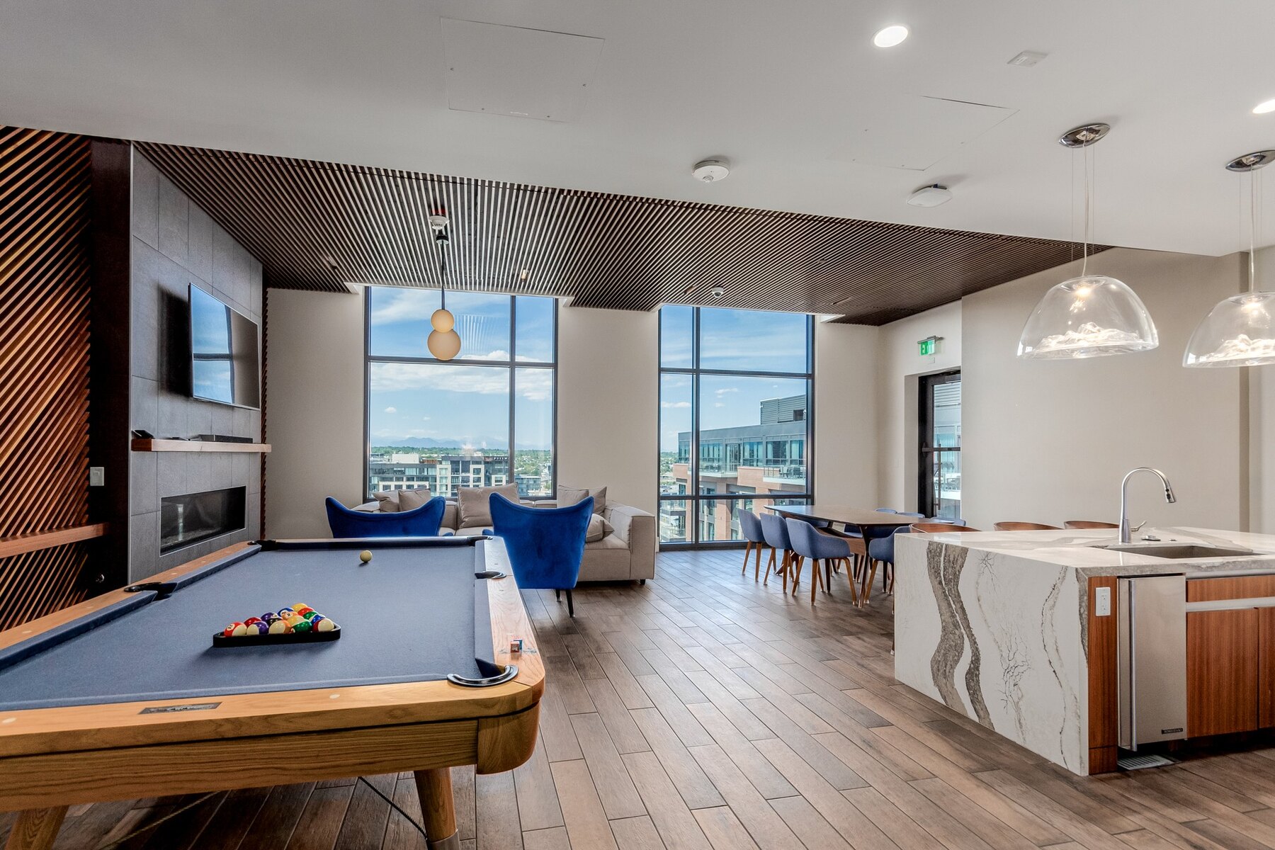 Upstairs community room game area with billiards and an open kitchen